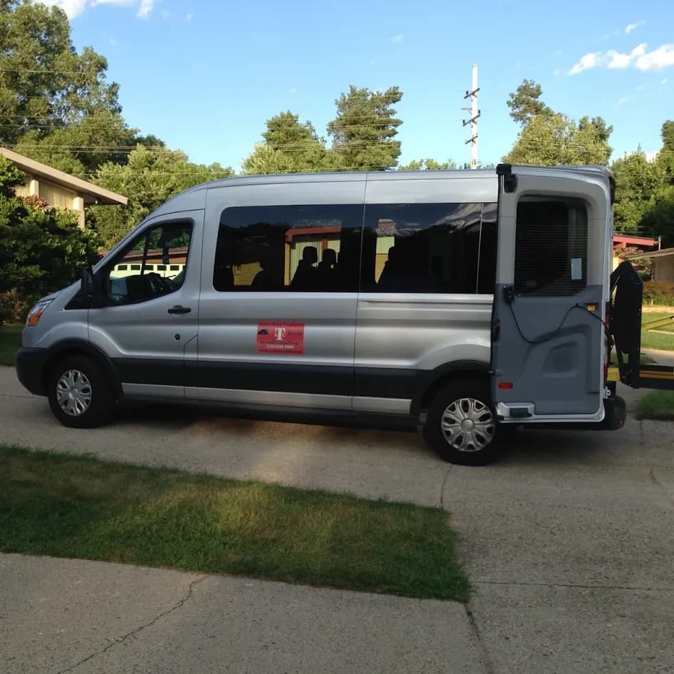 Side view of the branded transport van with its rear access door open.